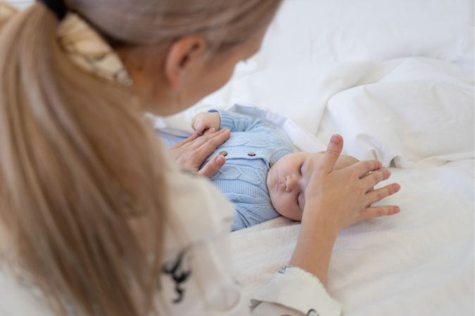 Maman qui touche le front de bébé