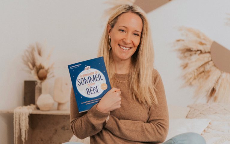 Caroline Ferriol, consultante en sommeil pour les bébés et les enfants, assise sur un lit, partage son expertise sur le sommeil et le bien-être des tout-petits à travers son livre.