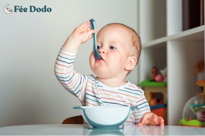 bébé qui mange à la cuillère