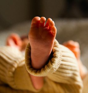 Pieds d’un bébé allongé sur le dos, moment calme de repos ou de jeu.