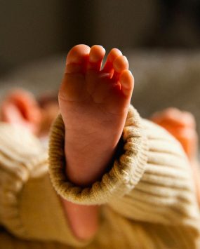 Pieds d’un bébé allongé sur le dos, moment calme de repos ou de jeu.