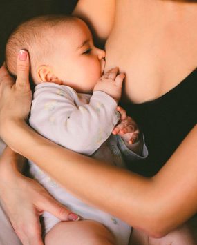 Maman allaitant tendrement son bébé, moment intime et apaisant d’allaitement au sein.